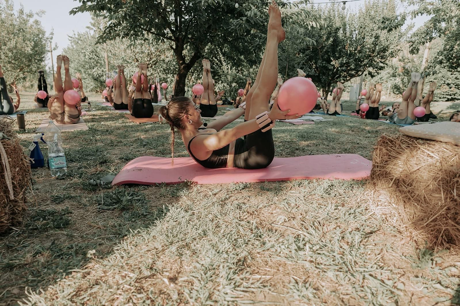 Laurona esegue un esercizio con la palla sul tappetino, tra le balle di fieno